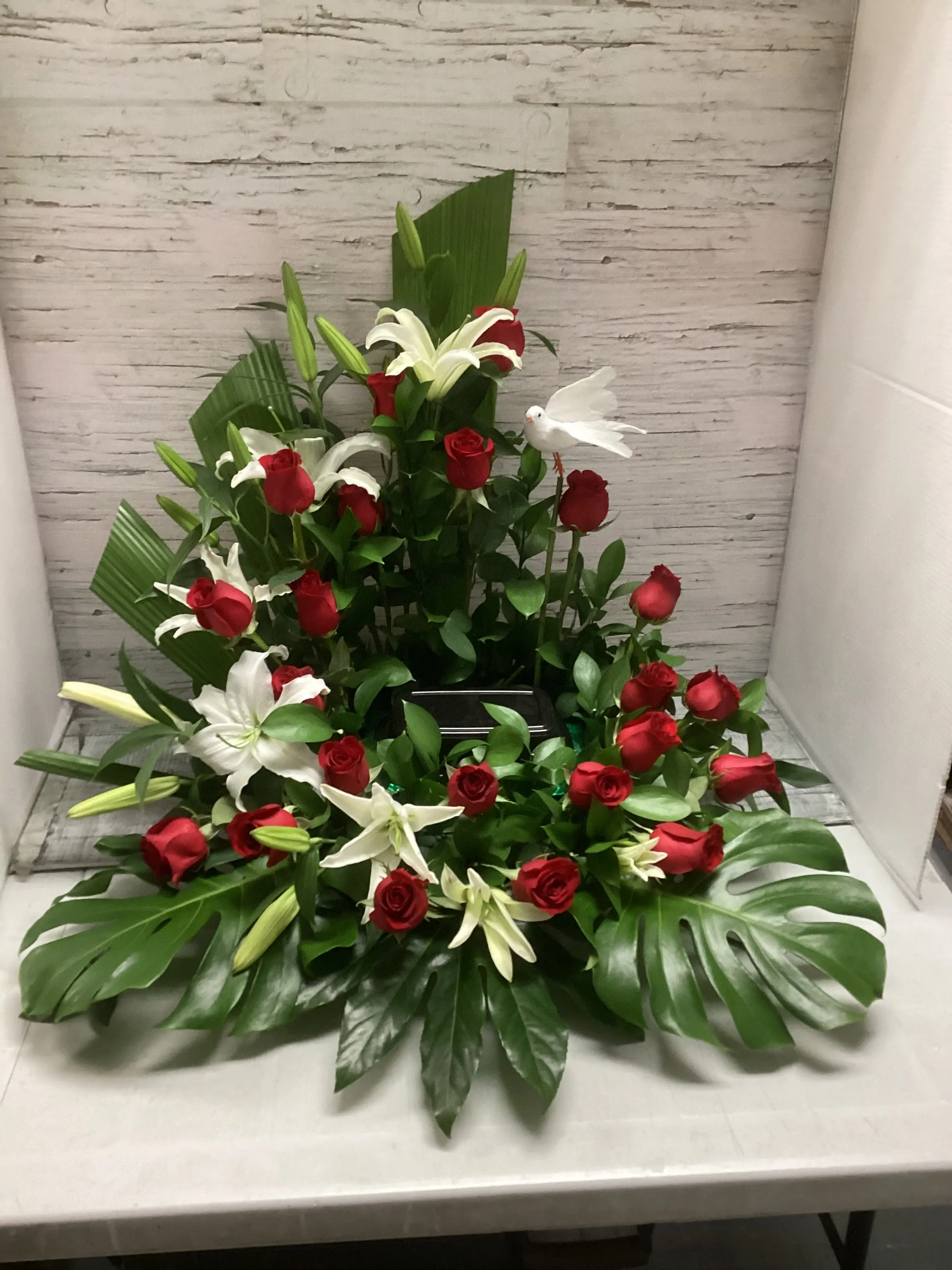 Arrangement funéraire roses rouges et lys blancs